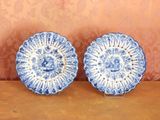 une paire d'assiettes bleues et blanches ornées de motifs, posées sur une table