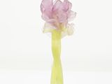 purple flower in a green vase on a white background