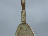 une ancienne figurine en bronze représentant une femme tenant un bébé dans ses bras, posée sur un vase