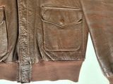 an image of a brown leather jacket hanging on a hanger