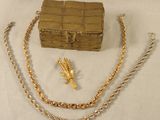 un collier en or, un bracelet et un coffret posés sur une table