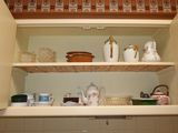 a shelf with dishes and cups on it in the kitchen