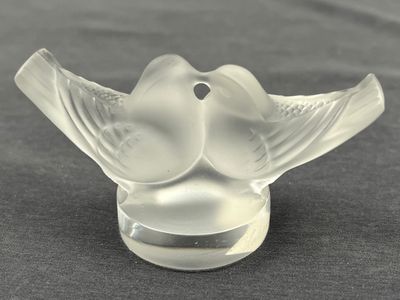 un oiseau en verre posé sur une table