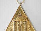 an image of a gold plated triangle with a book on it