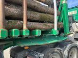 un camion avec un chargement de grumes à l'arrière