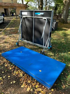 un matelas bleu posé par terre devant une maison
