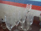 Plusieurs verres à vin vides sont posés sur une table devant un mur.