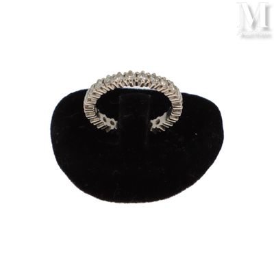 un gros plan d'une bague en diamant posée sur un présentoir en velours noir
