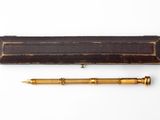un vieux stylo et une boîte en bois posés sur une surface blanche