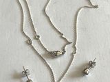 trois bijoux en argent posés sur une surface blanche