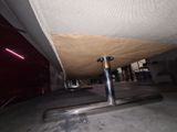 a metal pole that is under a bed in a room