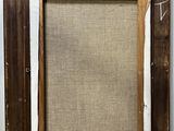 an old picture frame hanging on a wall with a piece of fabric