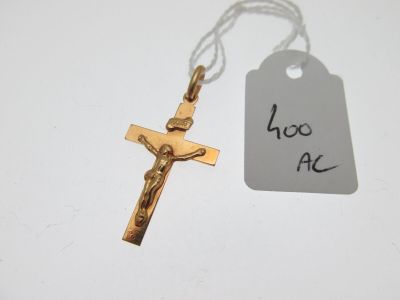 une petite croix et une étiquette posées sur une table blanche