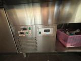 a machine that is sitting in a kitchen next to a trash can
