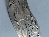 a silver spoon with flowers on it on a table