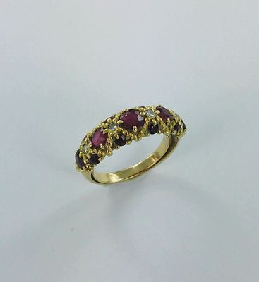 Gros plan sur une bague en or ornée de pierres rouges