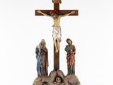 a statue of jesus on the cross with three people