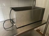 un grille-pain argenté posé sur une étagère en métal dans une cuisine