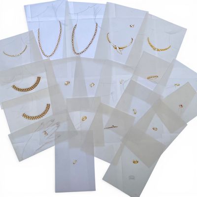 a bunch of white bags with gold chains and chains on them