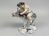 a figurine of a boy riding a donkey