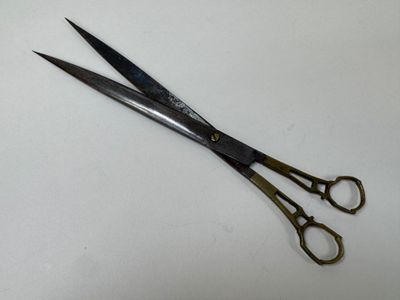 a pair of scissors on a table with a white background