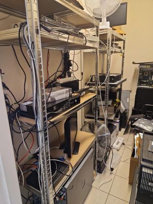 a room with a lot of wires and electronics on the shelves