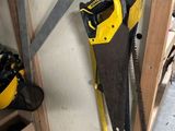 yellow and black saws are hanging on a wall in a garage