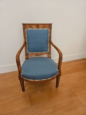 a wooden chair with a blue upholstered seat in the corner of a room