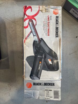 une boîte contenant un outil Black & Decker posée par terre