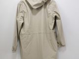 the back of a beige jacket hanging on a white wall
