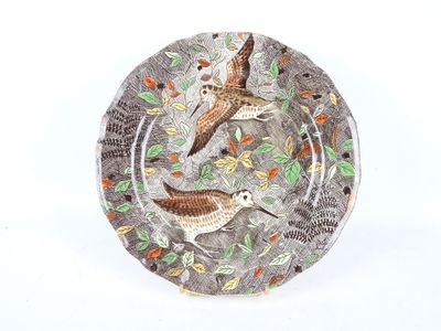 une assiette sur laquelle figurent deux oiseaux sur fond blanc