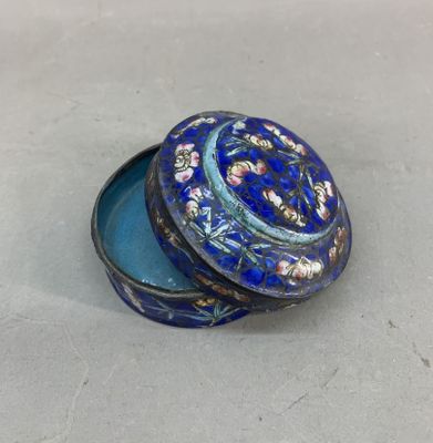 une image représentant une petite boîte bleue ornée d'un motif floral