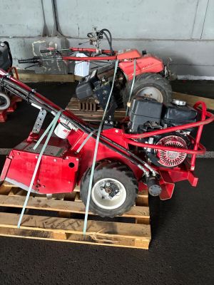 a small red tractor on a pallet in a garage