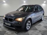 une photo d'un SUV BMW gris garé dans un garage
