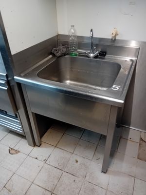 a stainless steel sink in the corner of a kitchen