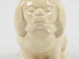 beige ceramic figurine of a dog with a sad face
