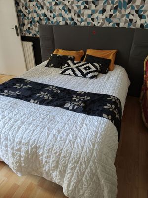 a bed that has a black and white blanket on top of it