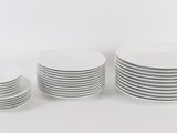 several white plates stacked on top of each other on a white surface