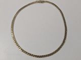 a close up of a gold necklace on a white surface
