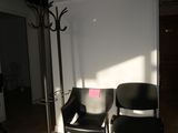 two black chairs sitting in a room next to a lamp