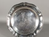 une assiette en argent avec un motif décoratif sur le bord