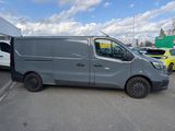 grey van parked in a parking lot with other vehicles in the background