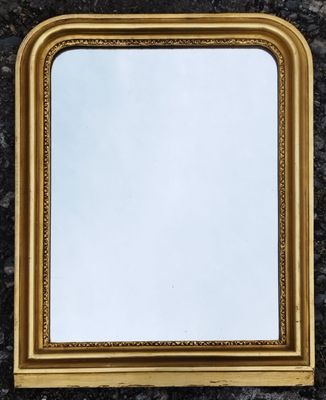 un miroir à cadre doré posé sur un plan de travail en marbre