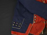 an old red and blue military jacket with buttons on it