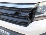 the front end of a white van with a denting front bumper