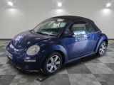une photo d'une Volkswagen Coccinelle décapotable bleue garée sur un sol à damier