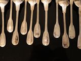 a lot of silver spoons and spoon spoons hanging from the ceiling