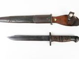 two knives are sitting side by side on a white surface