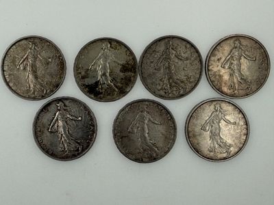 six different types of silver coins on a white surface