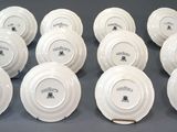 six white plates with black writing on them sitting on a table